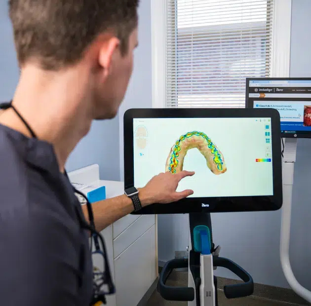 Cary NC dentist pointing at iTero digital scanner displaying teeth on screen