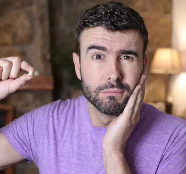 A man in cary NC holding missing tooth looking into missing teeth replacement solutions