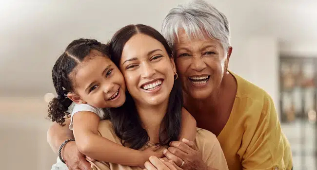 Daughter, mother, and grandmother smiling after restorative dental care in Cary, NC